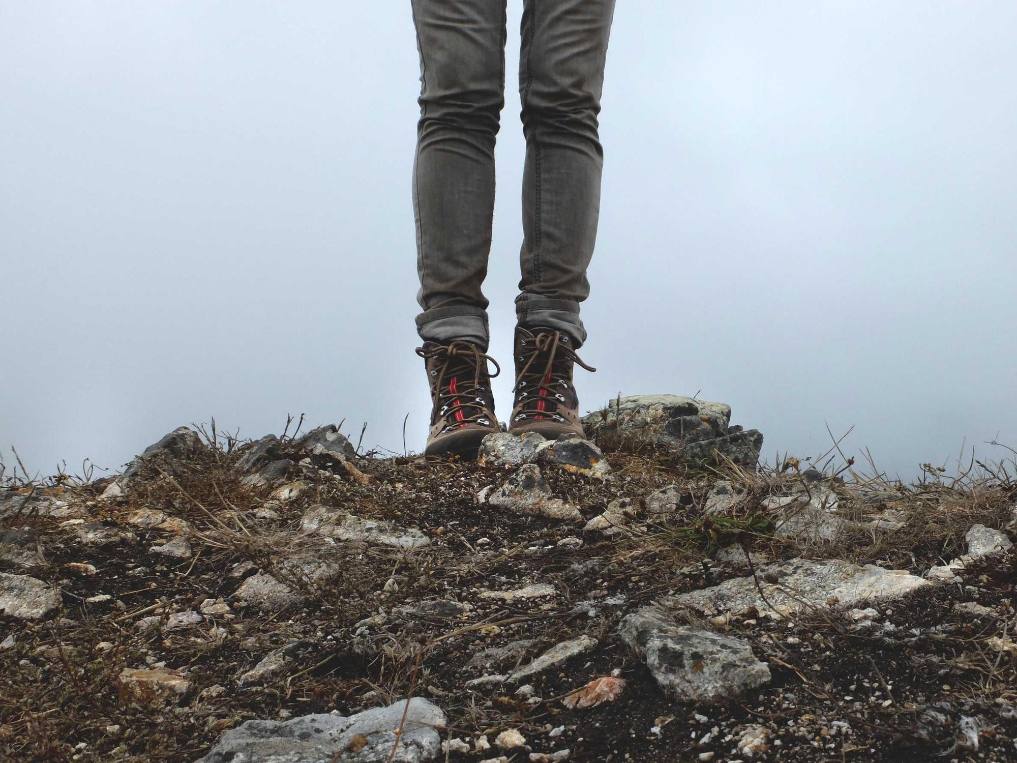 Wanderschuhe auf einem Felsen am Abgrund